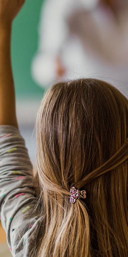 Kinder in der Schule heben die Hände