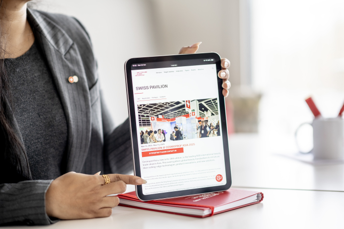 Person zeigt eine Internetseite auf einem iPad